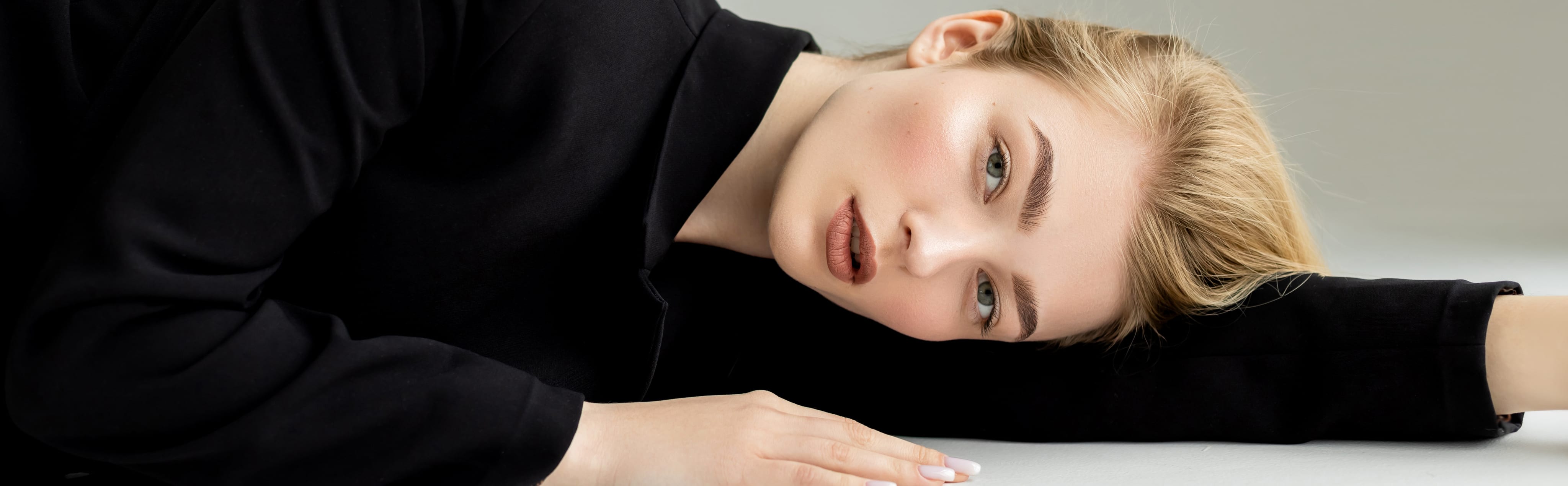 Woman with smooth, radiant skin resting her head on her arm