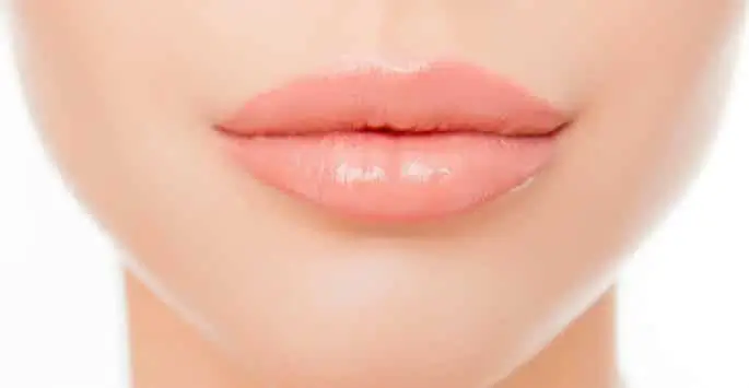 Close-up of a woman's pink, glossy lips.